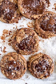 chocolate covered cookies on parchment paper with powdered sugar