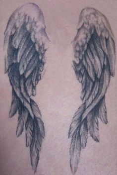 an angel wing tattoo on the back of a man