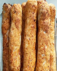 some bread sticks are sitting on a white paper plate and ready to be cooked in the oven