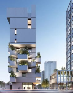 a tall building with plants growing on it's sides in front of other buildings