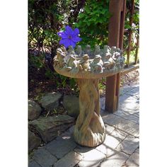 a bird bath sitting on top of a stone slab