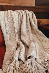 a white blanket sitting on top of a red chair