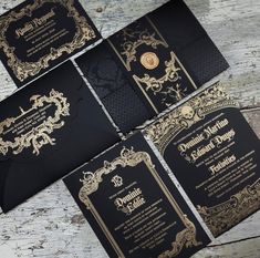 four black and gold wedding cards on top of each other, with an ornate design