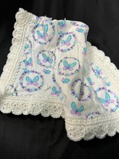 two white crocheted doily with blue butterflies on them, sitting next to each other