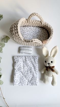 a crocheted basket, blanket and stuffed animal are laid out on a white surface