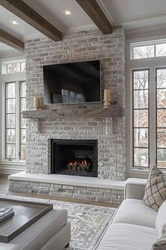 a living room filled with furniture and a flat screen tv mounted on the wall above a fire place