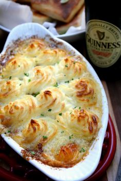 a casserole dish with cheese and bread on the side