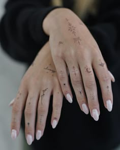 a woman's hands with tattoos on them