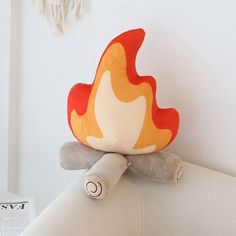 a fire pillow sitting on top of a white couch