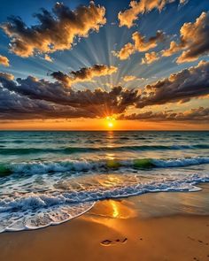 the sun is setting over the ocean with clouds in the sky and waves on the beach