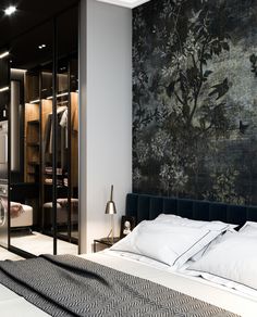 the bedroom is decorated in black and white with flowers on the wall behind it, along with mirrored closet doors