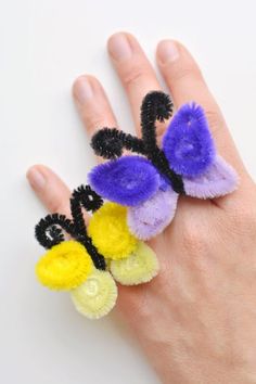 an image of a hand that has some kind of ring made out of pom poms