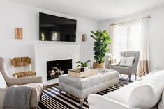 a living room filled with furniture and a flat screen tv mounted on the wall above a fireplace