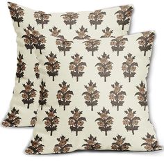 two pillows with leaves on them sitting next to each other in front of a white background