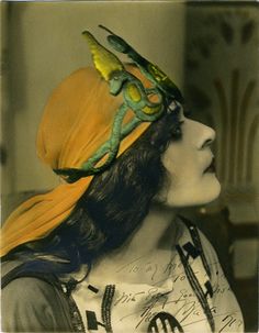 an old photo of a woman wearing a hat with a bird on it's head