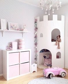 a child's bedroom decorated in pink and white with a princess castle on the wall