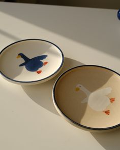 two small bowls with ducks painted on them