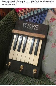 an old piano key case sitting on top of a couch next to pillows and a pillow