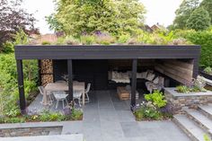 an outdoor living area with seating and plants on the roof, surrounded by greenery