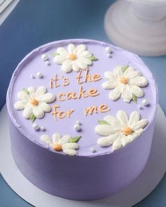 a purple cake with white flowers on it that says it's the cake for me