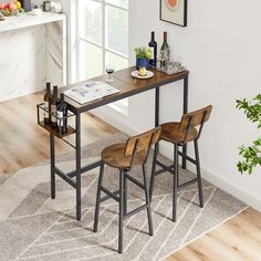 a dining room table with two chairs and a wine bottle on the counter next to it