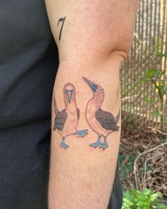 a man's arm with two pelicans on it and the number seven