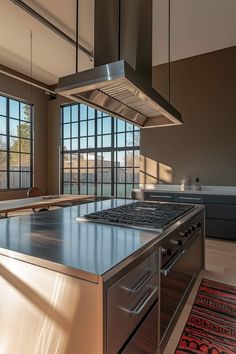 a kitchen with stainless steel appliances and large windows