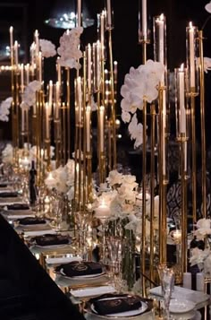 a long table with white flowers and candles on the top is set for an event