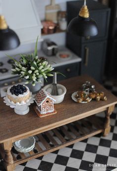 a wooden table topped with cakes and other desserts next to a potted plant