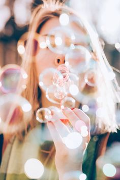 a woman blowing bubbles in front of her face