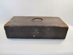 an old brown suitcase sitting on top of a white table