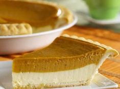 a slice of pumpkin pie on a white plate with a green cup in the background