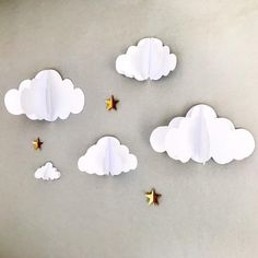 paper clouds and stars are arranged in the shape of an airplane on a gray surface