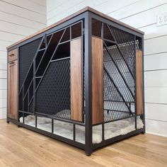 a caged in dog bed on top of a hard wood floor next to a white wall