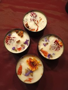 four bowls filled with different types of food on top of a red cloth covered table