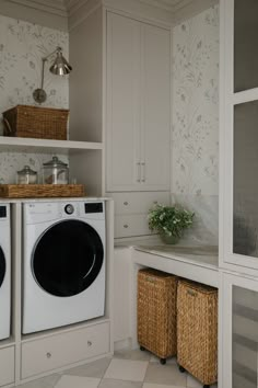 a washer and dryer in a white laundry room with floral wallpaper on the walls