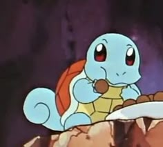 a blue and orange pokemon sitting on top of a rock next to another cartoon character