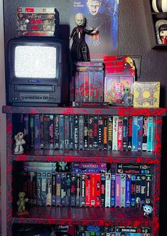 a book shelf filled with lots of books next to a wall mounted tv and movie memorabilia