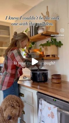 a woman is cooking in the kitchen with her dog