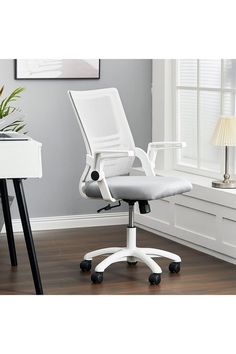 a white office chair sitting on top of a hard wood floor next to a window