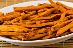 a white bowl filled with cheetos sitting on top of a bamboo place mat