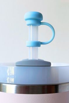 a blue object is sitting on top of a white table with a light blue handle