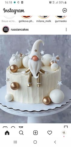 a cake with white frosting and gold decorations on it, sitting on a plate