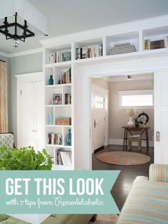 a living room filled with furniture and bookshelves next to a doorway that leads to another room