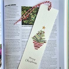 an open book with a christmas decoration on the front and back pages, in red and white twine