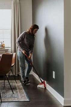 a woman is cleaning the floor with a mop