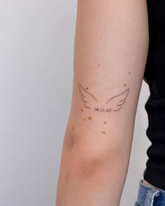 a woman's arm with a small tattoo on the left side of her arm