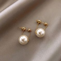 These small pearl pendant earrings are the perfect accessory for any woman looking for a simple and elegant look. The new fashion charm jewelry design is perfect for parties and other special occasions. These unusual dangle earrings are the perfect addition to any jewelry collection. These earrings are made of a copper alloy and are of classic style. They are fashion earrings and feature a drop design. The earrings are made with simulated pearls, perfect for women. They are made in China. Small Pearl Earrings, Pearl Pendant Earrings, Pearl Earrings Wedding, Long Dangle Earrings, Earring Type, Pearl Earrings Dangle, Gold Earrings Dangle, Mua Sắm, Simple Earrings