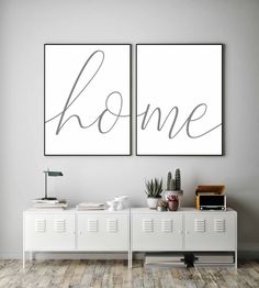 two posters with the word home on them in a room next to a white cabinet