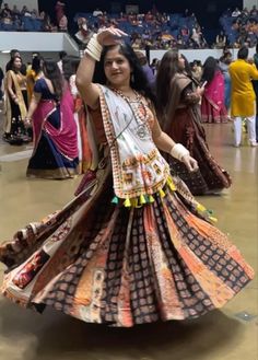 a woman is dancing in a colorful dress